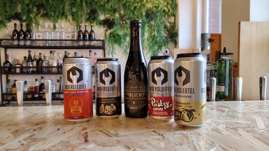 Four Moersleutel cans and a bottle of Indulgence 30 on the Taproom bar, with the back bar and greenery behind