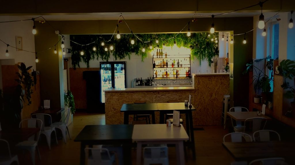 The Taproom at The Bach, empty and lit, with festoon lights and greenery over the bar