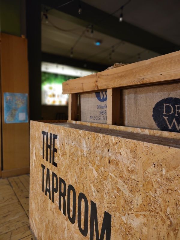 The Taproom sign, painted on a plywood counter at The Bach